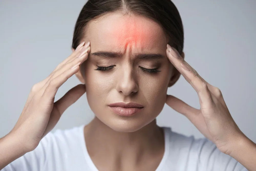 Patient experiencing forehead and temple discomfort associated with migraine